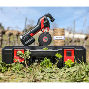 Infaco tool sitting on top of carrying case with spool of wire with a blurred vineyard in the background
