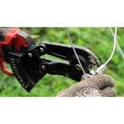 a Strainrite crimping tool being used on a wire fence against a blurred green background